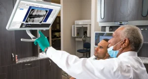 Doctors looking at a computer screen displaying teeth xrays